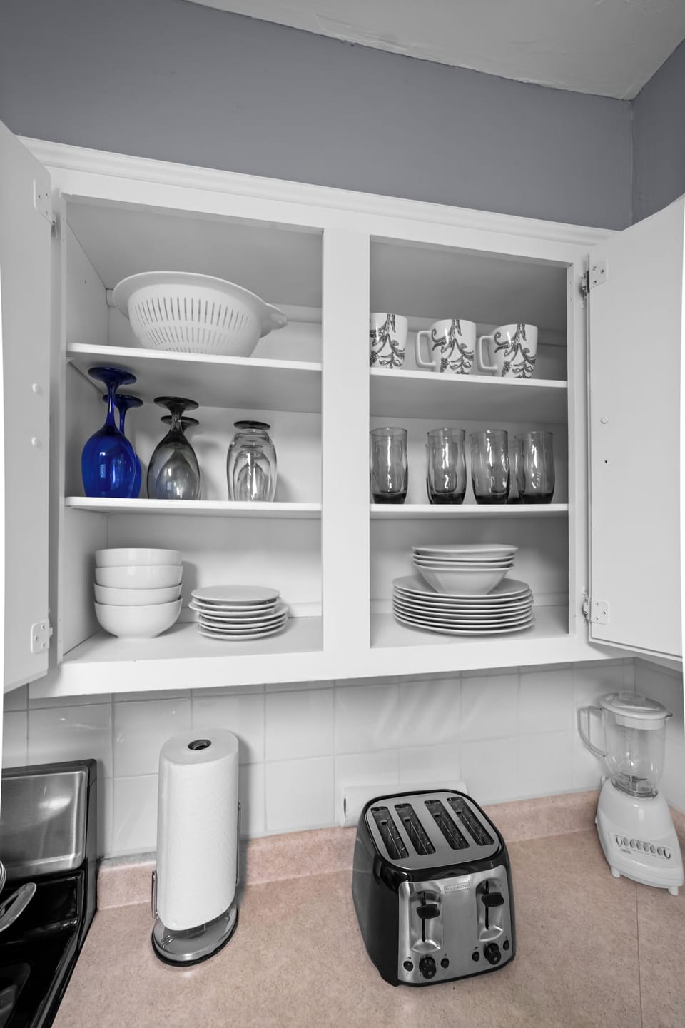 Kitchen closet with water glasses, wine glasses and  other dishes