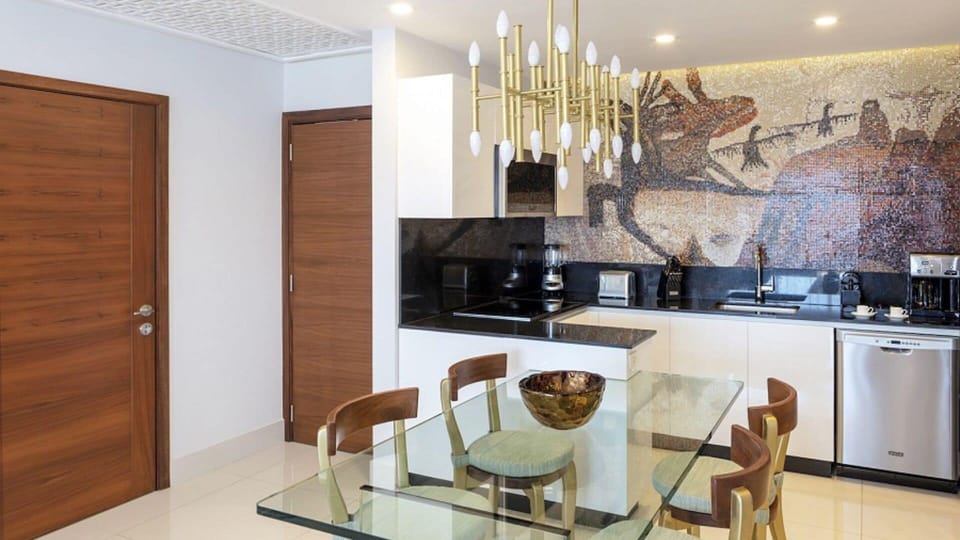 Modern kitchen with stylish decor and unique mosaic backsplash.