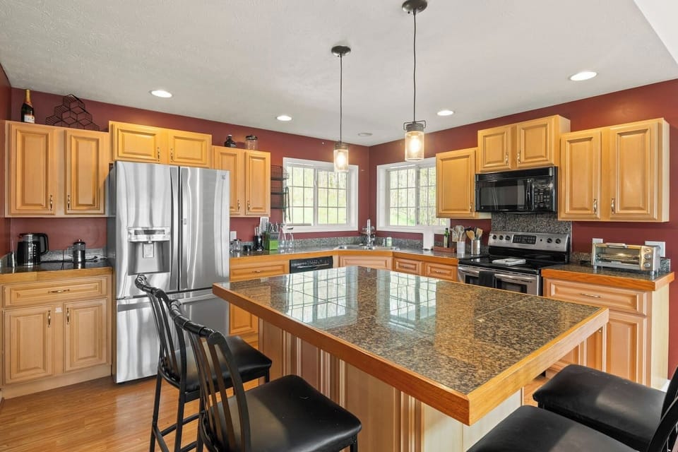 Enjoy this well-equipped kitchen featuring sleek granite countertops and a spacious layout, perfect for culinary enthusiasts and social gatherings. 