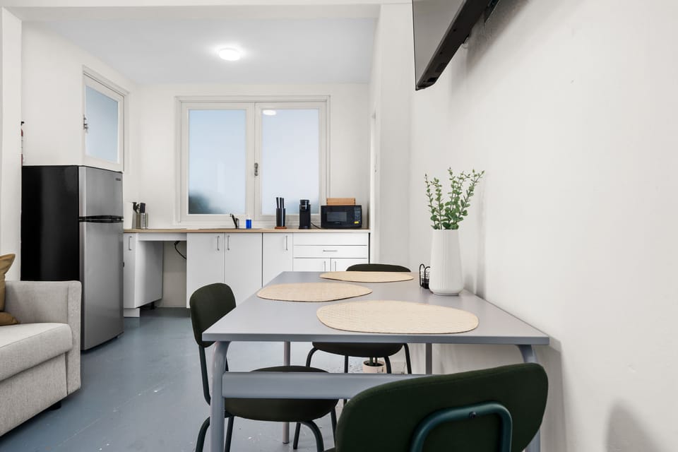 Prepare light meals and leftovers with this convenient kitchen featuring a refrigerator, sink, and microwave and a dinning area.