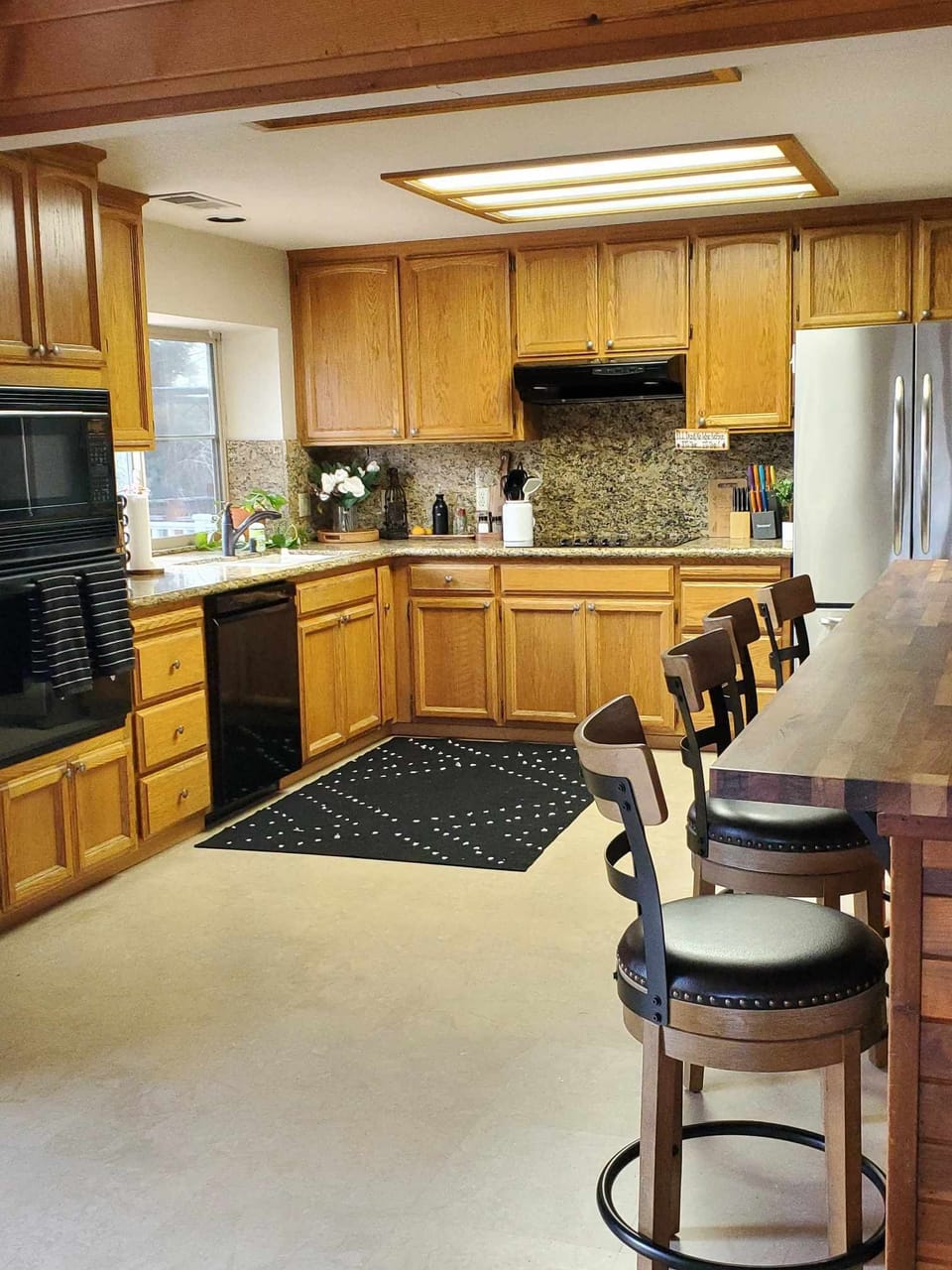 Kitchen view showing bar area, stove, frig, oven, dishwasher