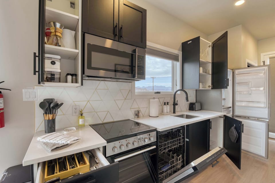 Full Kitchen. Plates, glasses, cups, silverware, pots & pans, cooking utensils, oil, spices, coffee maker, coffee, tea, creamer, kettle, toaster, dishwasher and full fridge/freezer