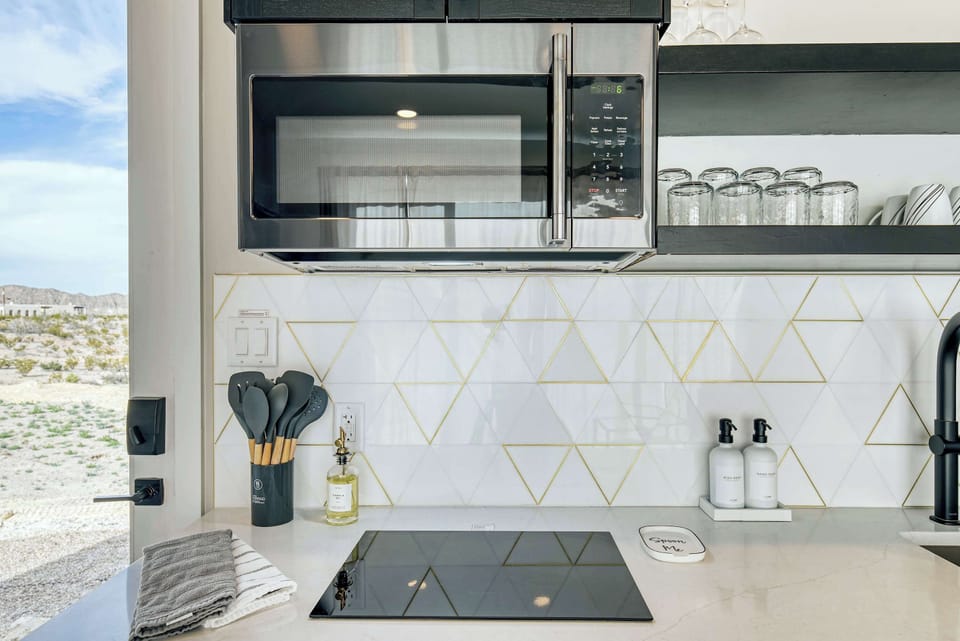 Induction cooktop and microwave. Cooking utensils, pots, pans, oil, and spices are provided