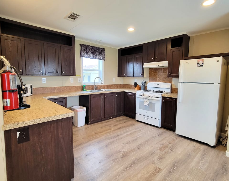 There is a full kitchen with a refrigerator, gas stove, and microwave.