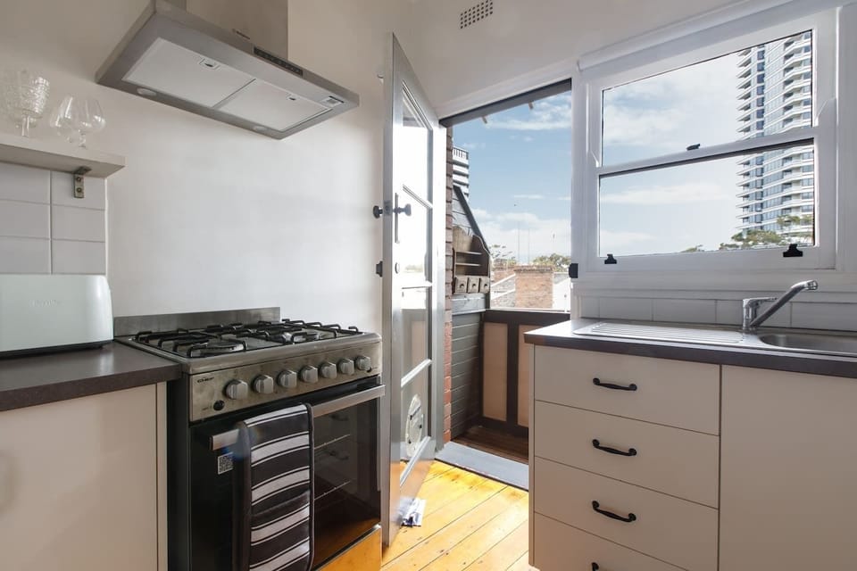 The bright and breezy kitchen has an adjoining balcony with sun filled windows that illuminate the space. 
