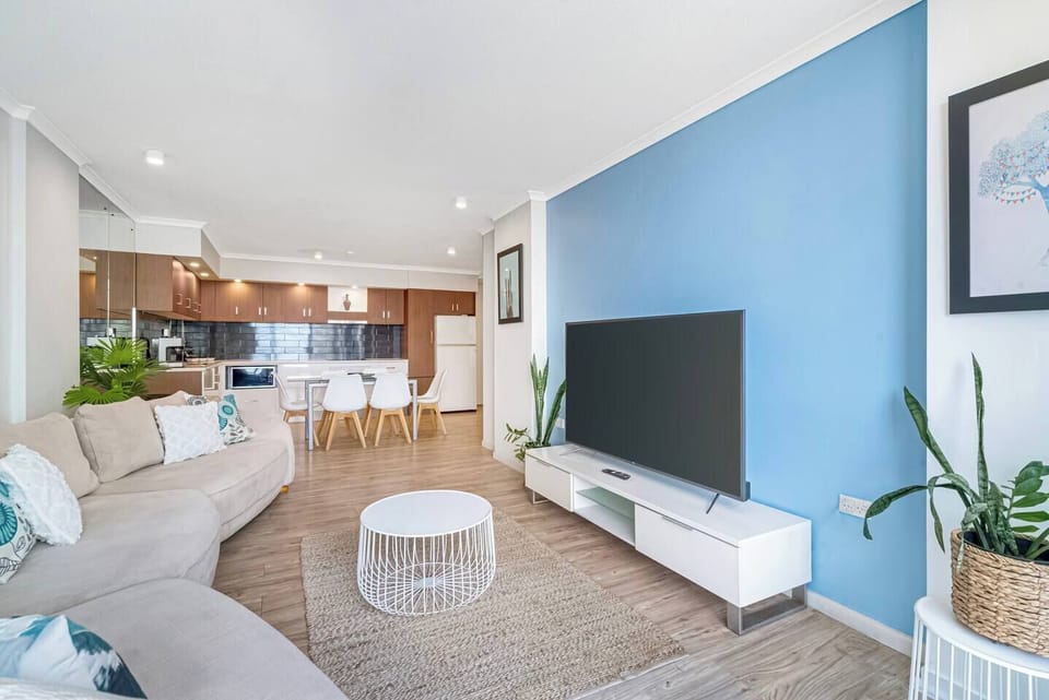A bright and airy living area offers a generous sofa and TV where you can kick back with some Netflix in air-conditioned comfort.