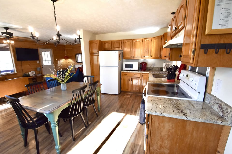 Morning light streams into open, full kitchen well equipped for cooking/baking.