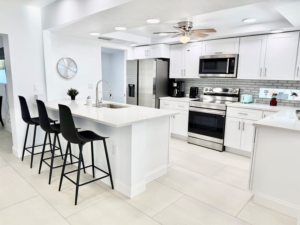 This fully updated kitchen offers sleek finishes, ample counter space, and an oversized island that serves as both a prep area and casual dining spot.