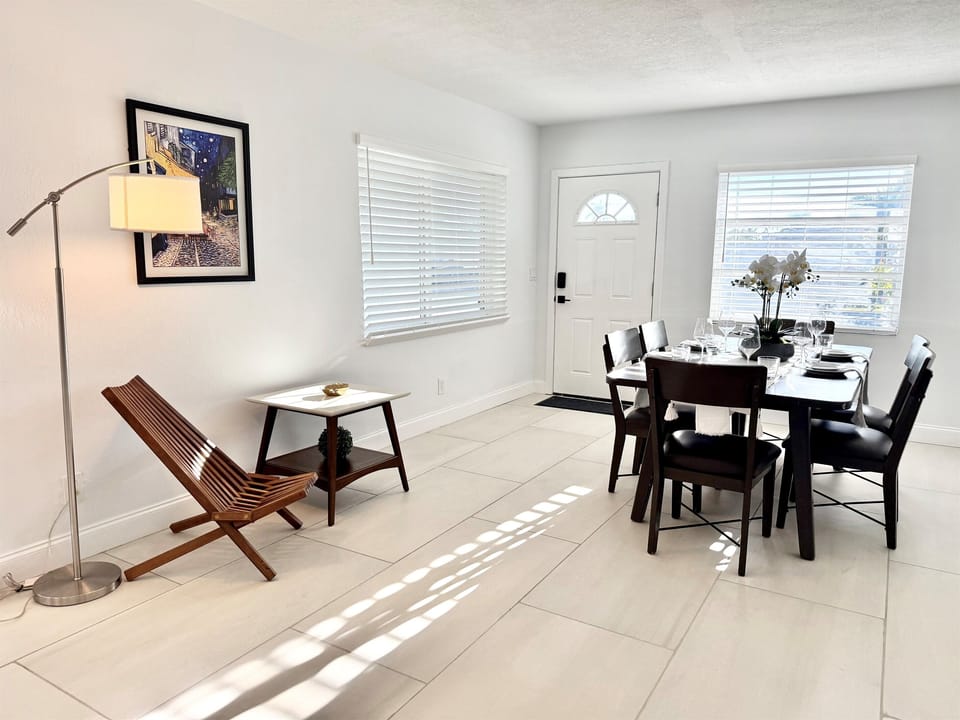 Light-filled and modern, the dining room showcases sleek tile flooring, simple décor, and a welcoming atmosphere ideal for shared meals.