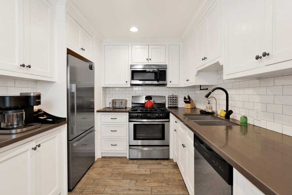 Bright and spotless kitchen featuring modern appliances, ample counter space, and all the essentials for easy meal prep during your stay.
