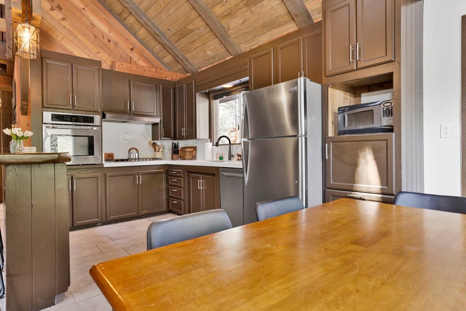 Fully equipped cabin kitchen with ample cabinetry, stove, fridge, microwave, and coffee maker—perfect for cooking meals, morning coffee, and feeling right at home on your stay.