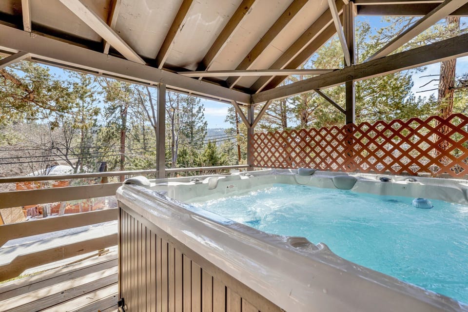 Private outdoor hot tub, surrounded by tall pines, perfect for relaxing under the trees after a day of adventure—enjoy peaceful forest views, fresh air, and a truly rejuvenating stay.