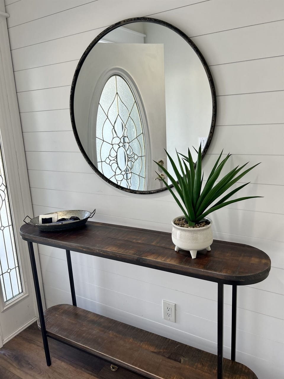 Admire your reflection in this stylish round mirror while enjoying the fresh greenery brightening your space.