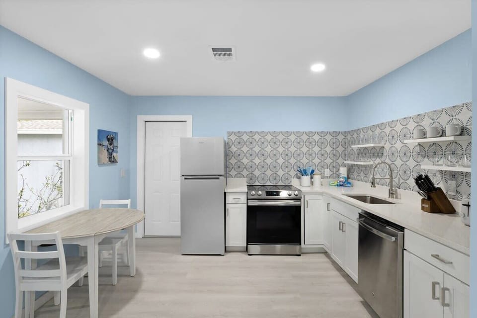 Fully stocked kitchen with brand new appliances and cute dining table overlooking front driveway