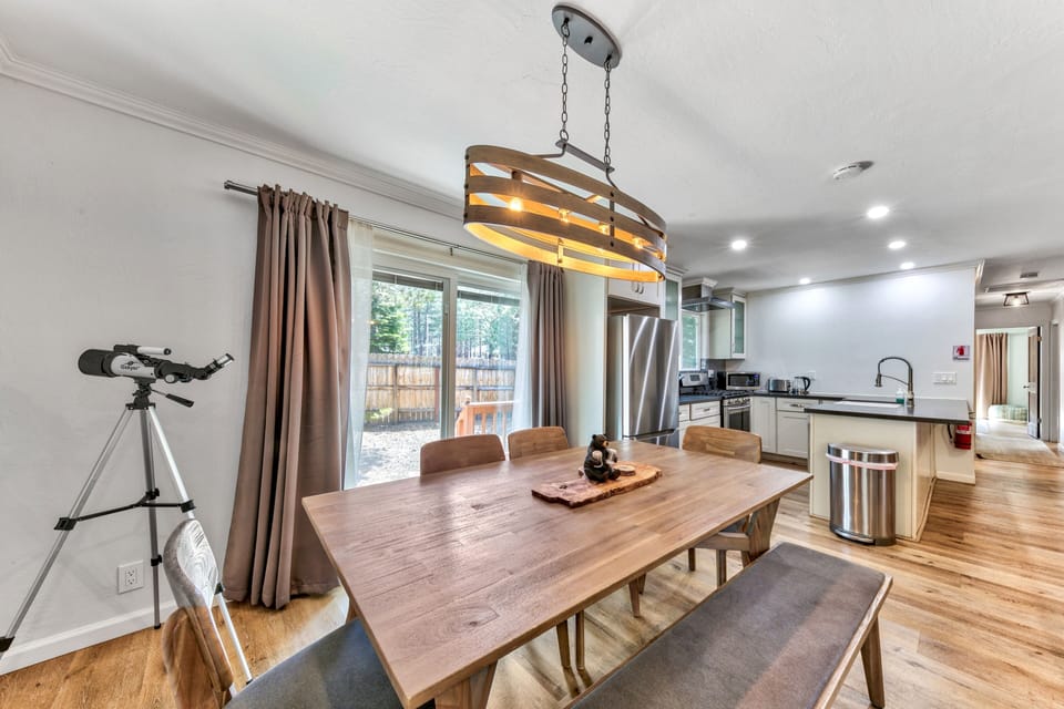 Gather around your spacious dining table under warm pendant lighting, with a modern kitchen and telescope for stargazing nearby.