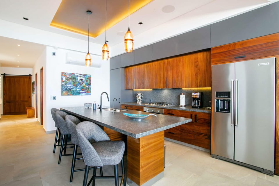 The modern kitchen boasts a stylish bar, comfortably accommodating seating for four