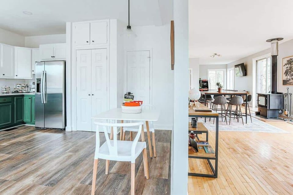 Bright kitchen with white cabinetry and dining space beyond.