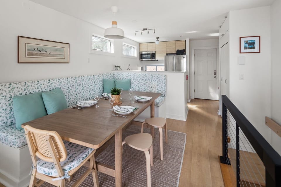 - Dining table with modern bench seating and natural light flow   - Kitchen equipped with stainless appliances for vacation cooking   - Airbnb listing designed with open dining and cooking spaces