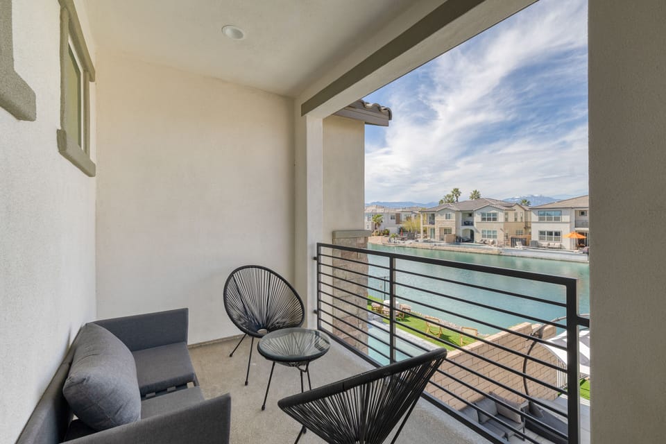 Balcony off the primary bedroom overlooks the water.