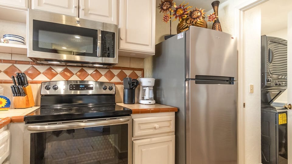 Off of the kitchen is the entrance to a utility room with a sink, washer, and dryer.