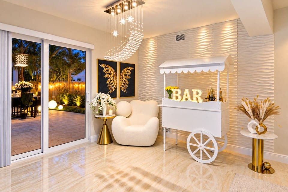 Luxury Indoor-Outdoor Living! Crystal waterfall chandelier, BAR cart, sculptural seating & butterfly artwork flow seamlessly to tropical patio. Textured walls & gold accents create Instagram magic. Hollywood Beach villa with game rooms, hot tub & beach!