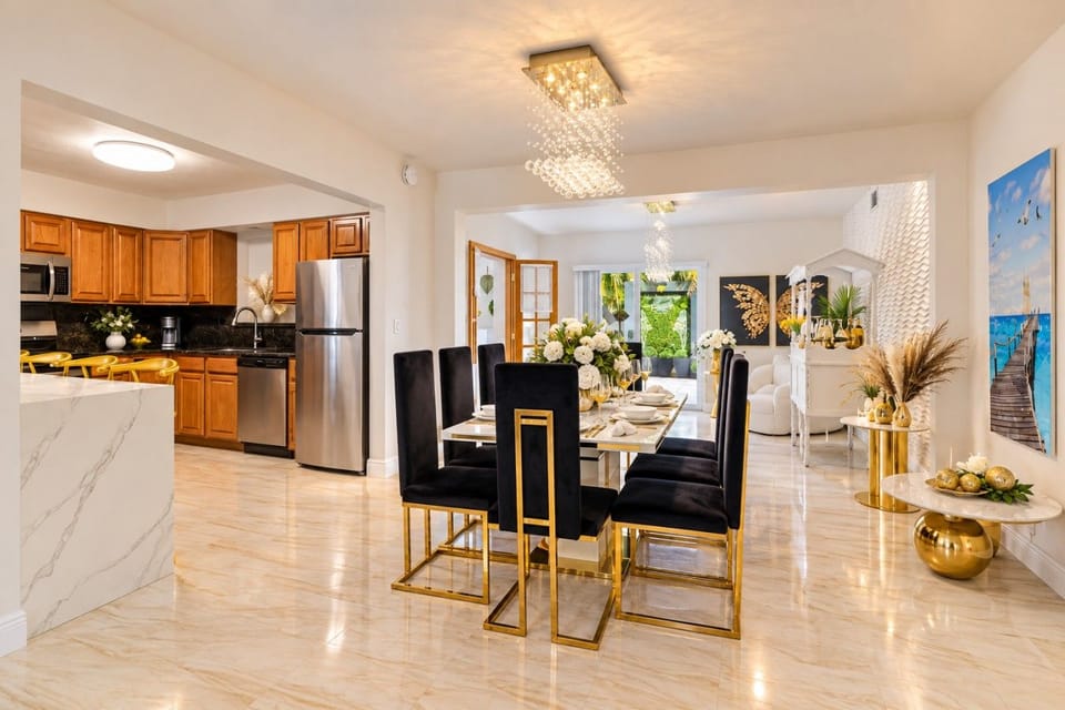 Stunning Open Concept Living! Kitchen, dining & lounge flow seamlessly with crystal chandelier, gold accents & modern design. Seats 8+ comfortably for entertaining. Hollywood Beach villa with game rooms, poker tables, hot tub & beach 3min away!