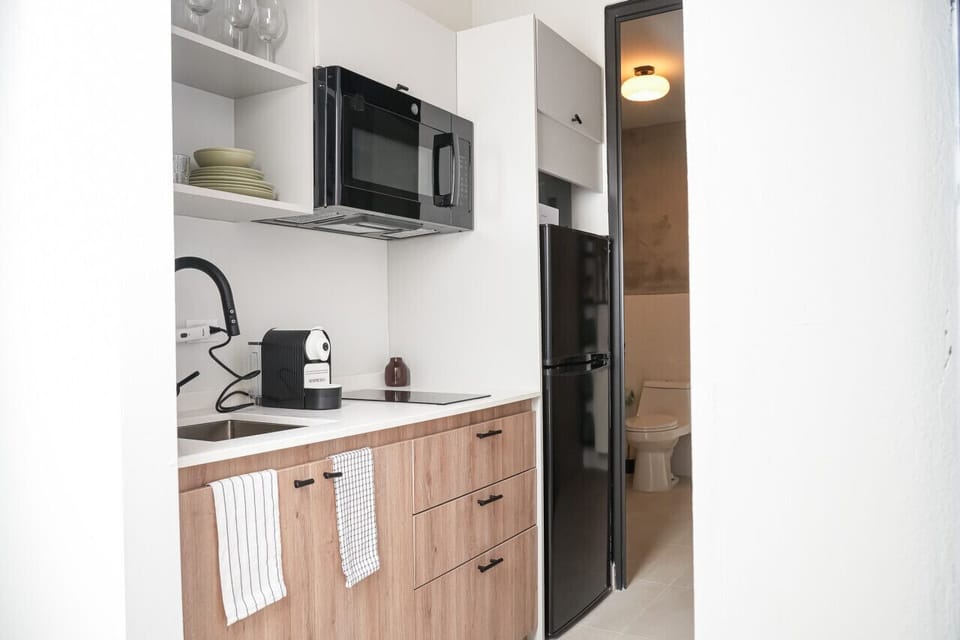 Kitchen with refrigerador, microwave, stove and cutlery, pans, pots, equipped for 2.