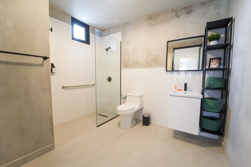 Wheelchair accesible bathroom with towels, toiletries, blowdryer and iron.