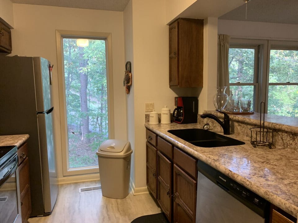 Fully equipped kitchen with all major appliances and a beautiful forest backdrop — perfect for extended stays.