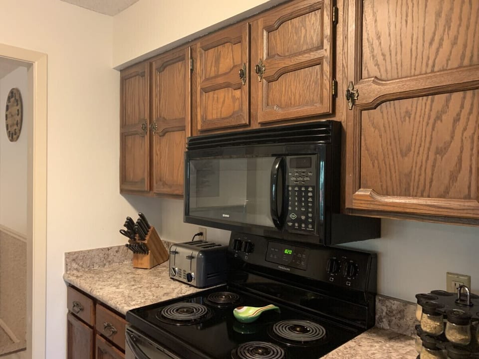 Classic kitchen setup with modern black appliances and plenty of counter space — fully stocked for your cooking needs.