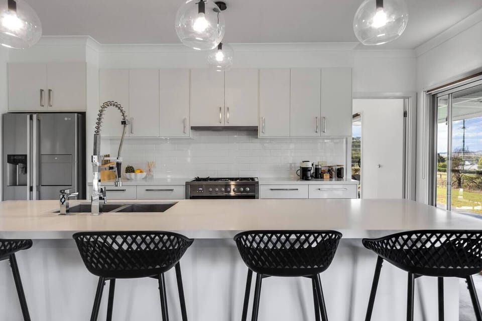 The kitchen is situated in the comfort of air-conditioning and sunshine with a breezy door accessing the veranda. 
