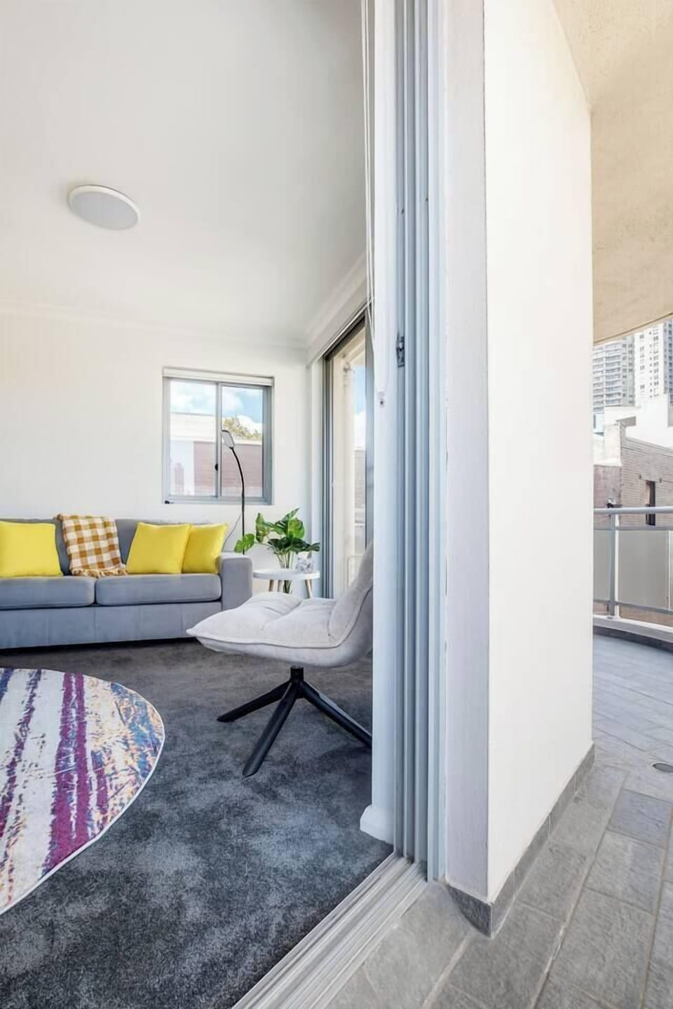 The living area opens through sliding doors to the balcony, creating a lovely transition between indoors and out.
