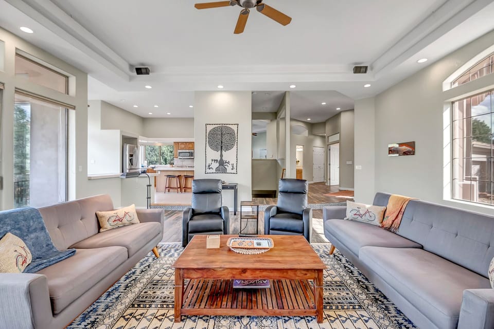 Living area with sofa seating, two reclining chairs, 60” Smart TV, and electric fireplace