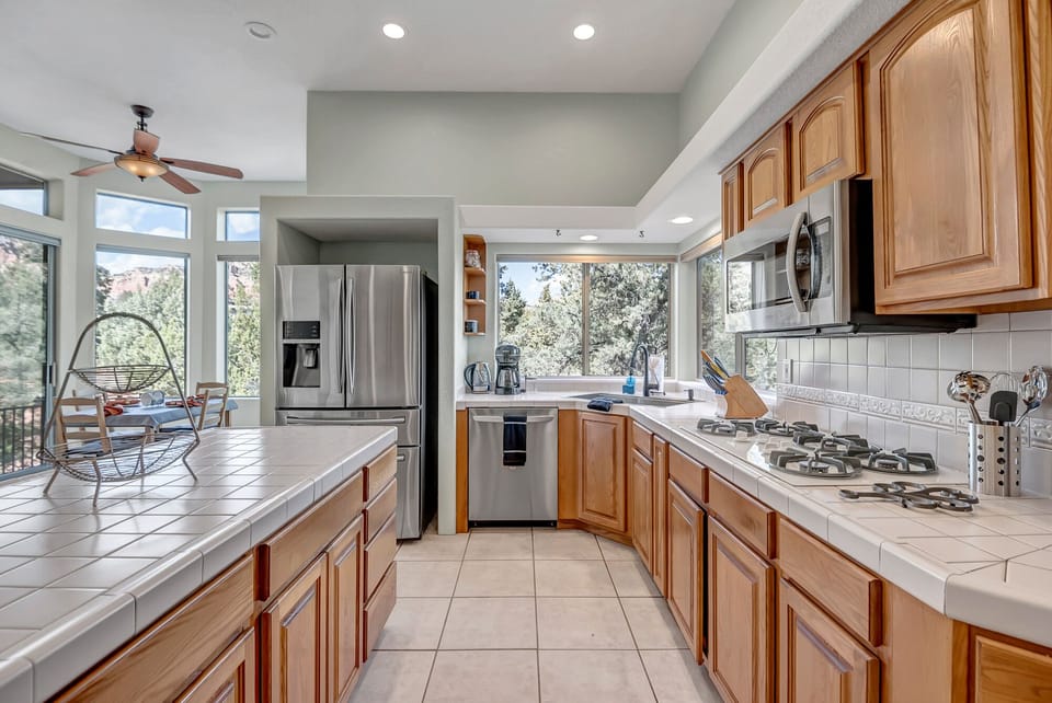 Fully equipped kitchen boasts high-end appliances, a 5-burner gas stove, and island seating for two