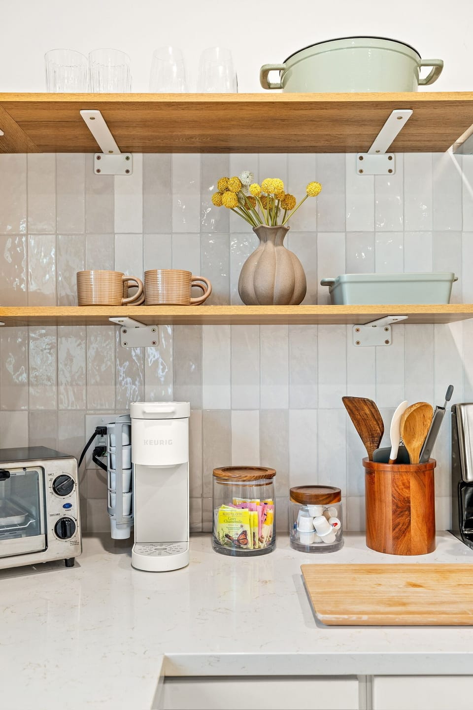 toaster oven, coffee machine, coffee, creamer, sugar, teas,  and utensils. 