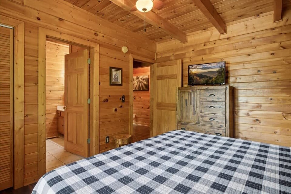 Rustic charm with wooden walls, comfy bed, and a tranquil view awaits you!