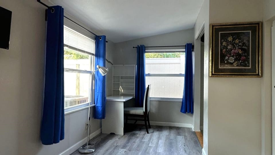 Bedroom features queen size bed, TV, closet, and a murphy desk.
