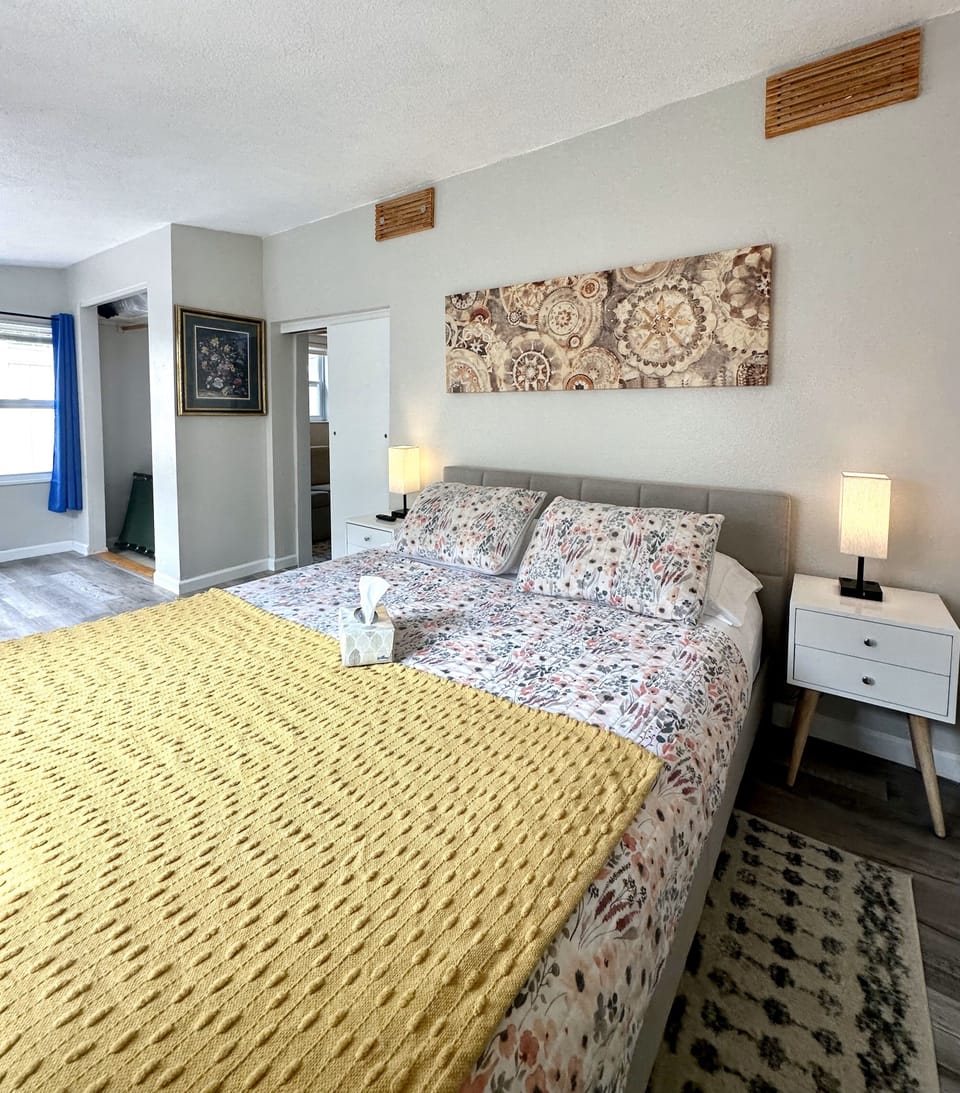 Bedroom features queen size bed, TV, closet, and a murphy desk.