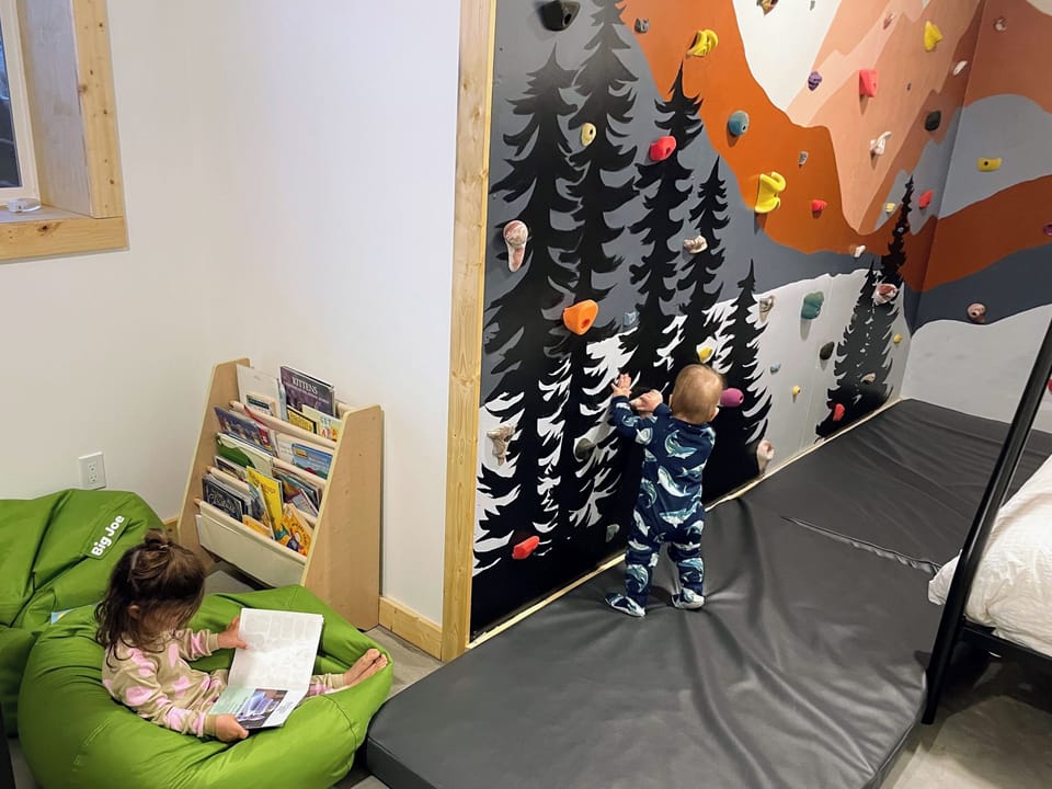 'Cousins' room with climbing wall, bean bag chairs, kids books, 3x double beds, 1x twin bed