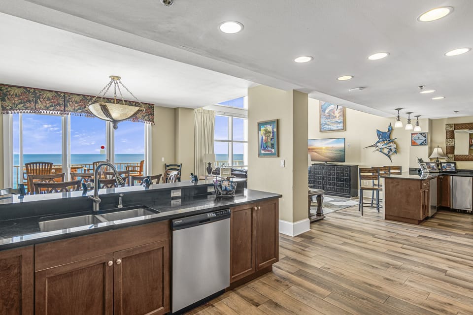 Spacious, Open Living Area with multiple kitchen and dining spaces, comfortable living room, and Huge Gulf and Beach views through floor-to-ceiling windows!