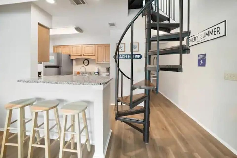 View of kitchen and spiral stairs to the loft. 