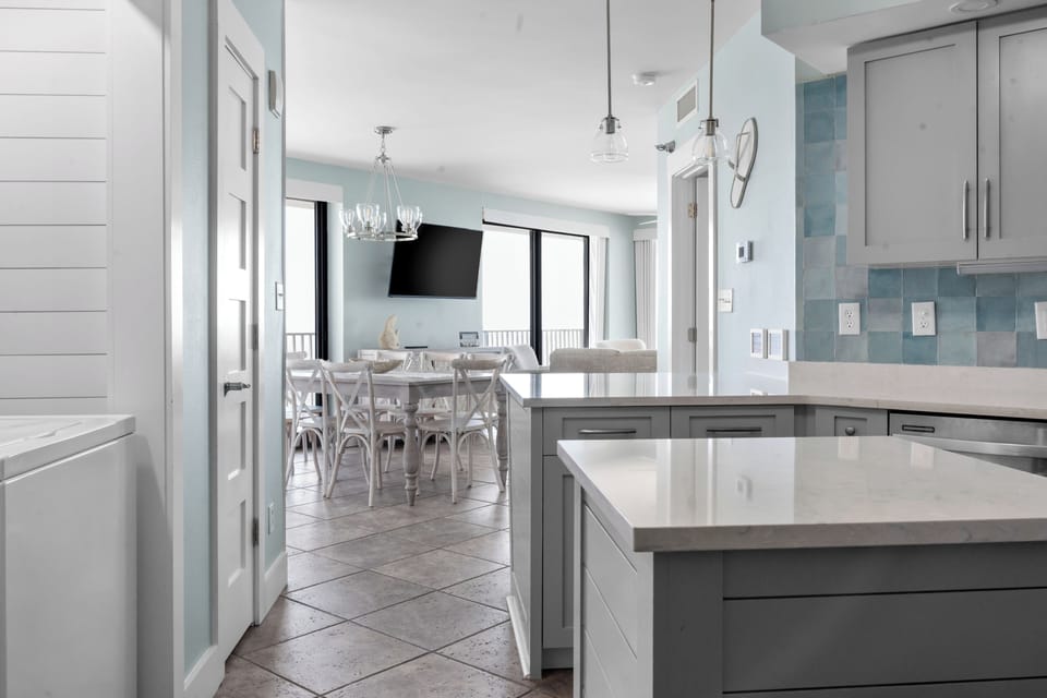 Bright coastal kitchen and dining space with elegant, airy design