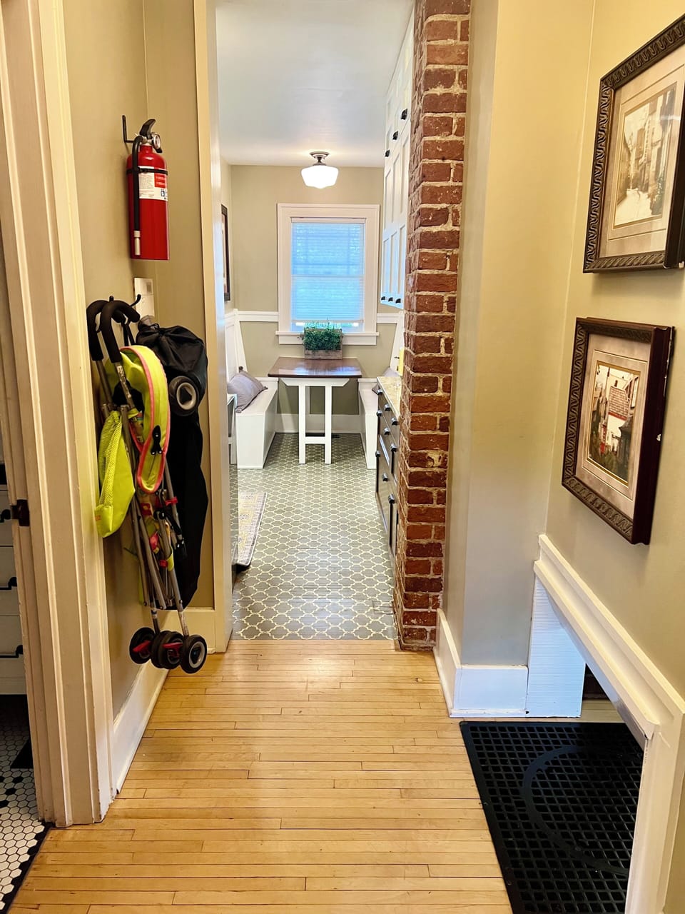 Umbrella stroller & portable high chair hung on hallway wall.
