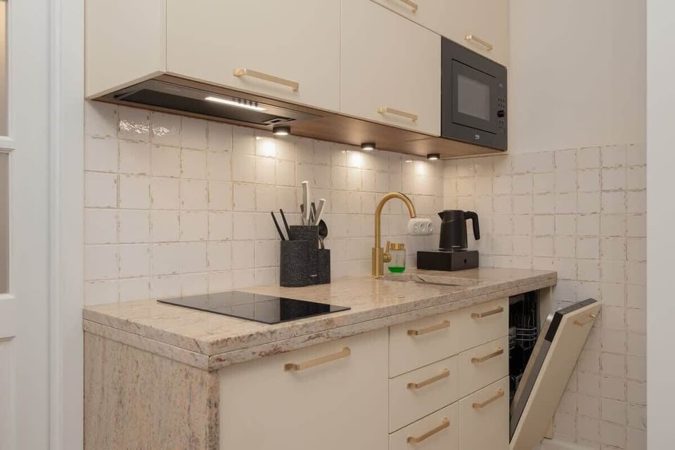 The efficiently arranged cooking area with tiles and essential appliances allows you to prepare home-cooked meals with ease.