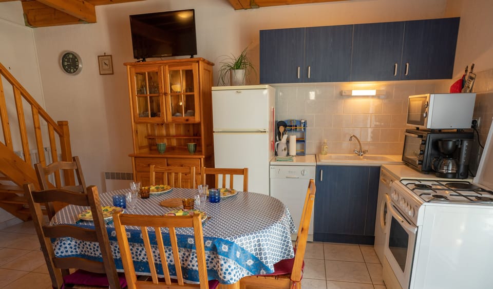 Fully equipped kitchen with dining table, TV, armchair and air conditioning