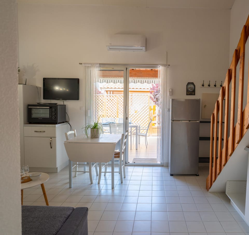 Kitchen opening onto living room. With coffee machine, toaster, oven etc.