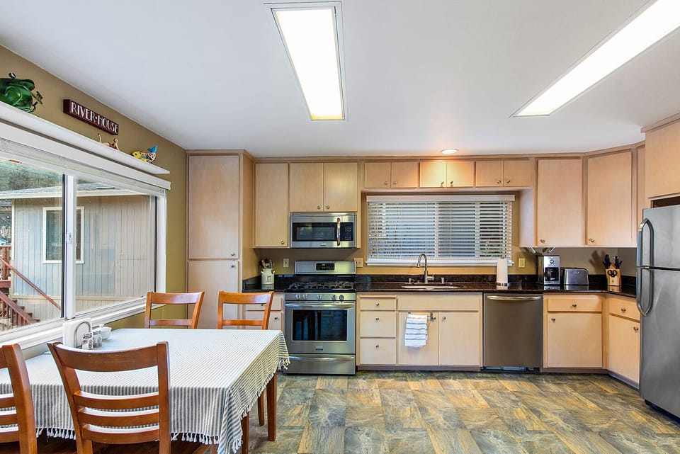 Wide open kitchen with stainless steel appliances and gas range.
