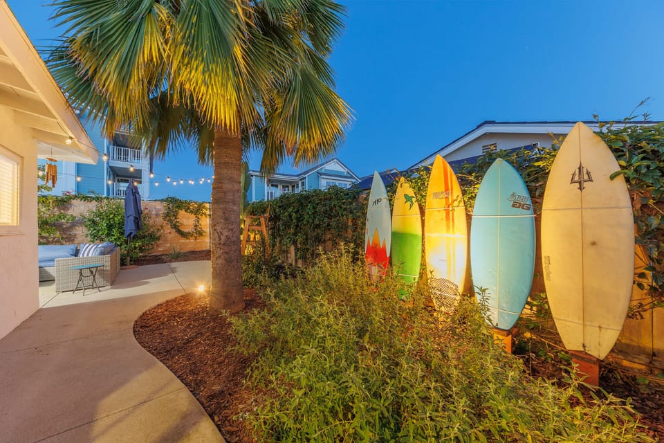 Garden pathway with surfboard wall display and tropical plants l