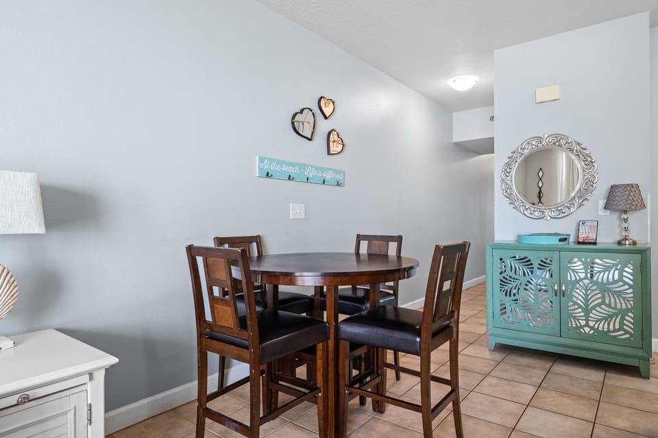 Gather around this welcoming dining space, where coastal charm meets homey comfort. The thoughtful beachy decor and ample seating make every meal feel special.
