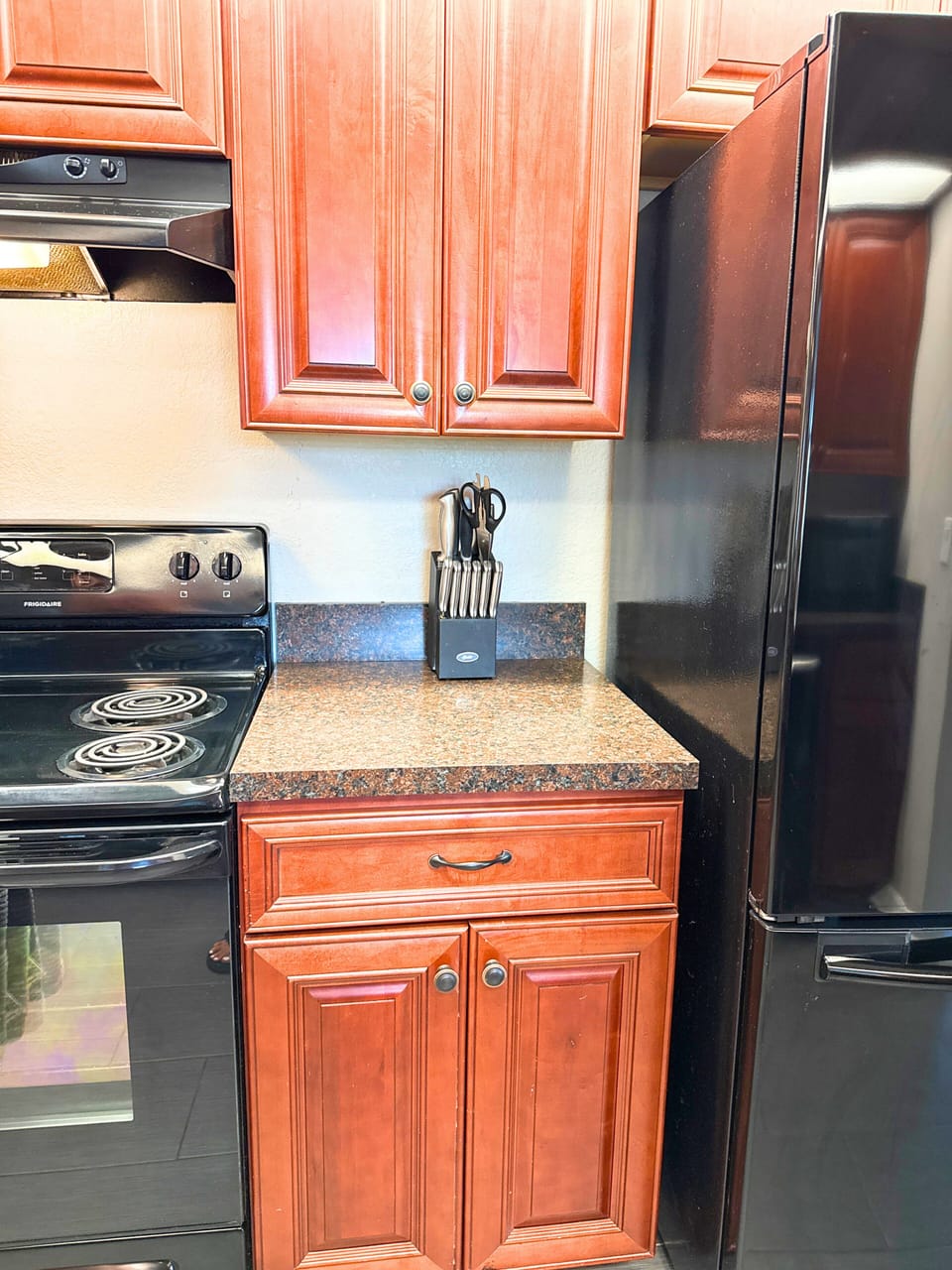 Kitchen features essential appliances, also includes a counter with 2 bar stools